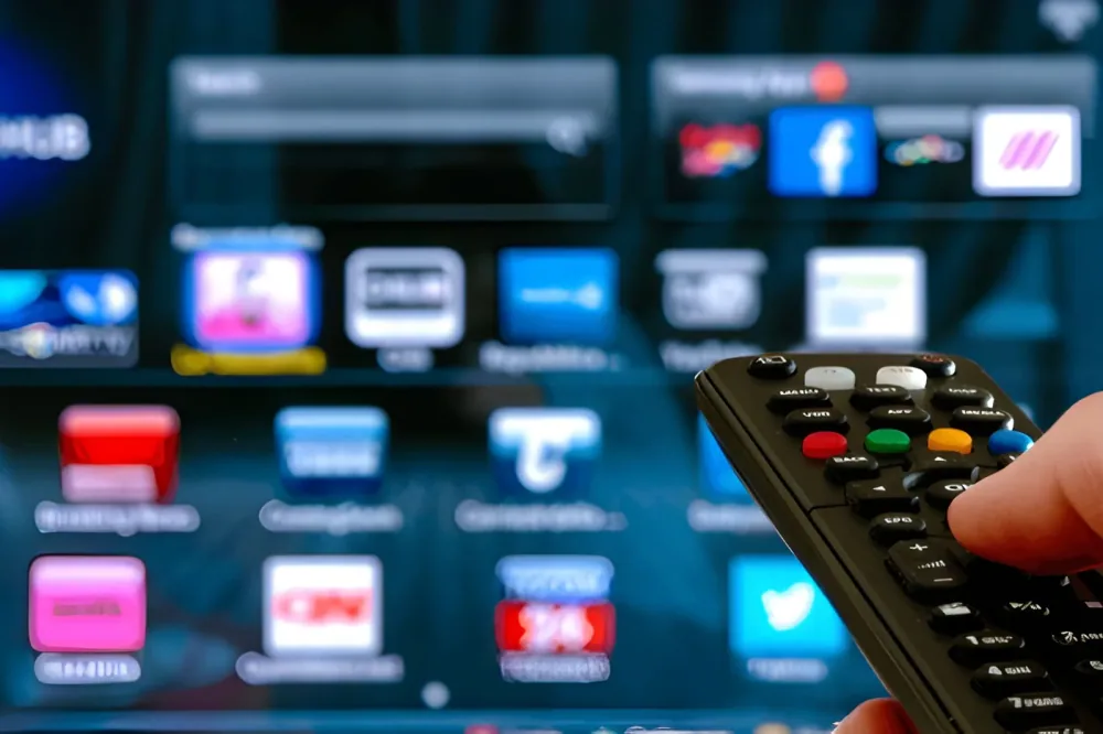 Fernbedienung vor einem Fernseher mit einer Auswahl an Anwendungen
